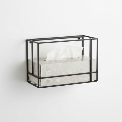 Matte black wall-mounted metal tissue box holder on white wall with tissue box inside