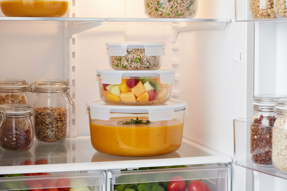 Stacked glass containers with meal prep food inside refrigerator